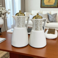A set of tea and coffee thermoses in several colors with prominent golden decorations and a golden lid.