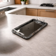 A rectangular serving tray made of polished stainless steel with acrylic handles.