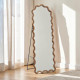 Elegant floor mirror with a luxurious wavy design.