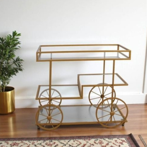 A stylish and elegant display stand with a gold-tone glass top.